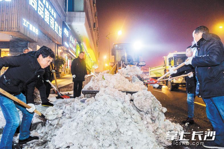 昨晚9時,，車站北路，芙蓉區(qū)湘湖街道城管工作人員正在對路邊的積雪進行統(tǒng)一清理,。 長沙晚報記者 鄒麟 攝