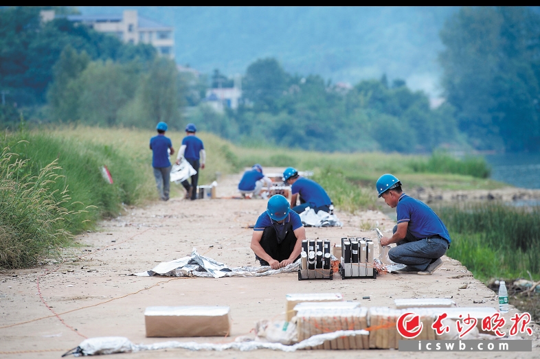 　　工作人員用錫紙為煙花組做防潮防火工作，這是正式燃放前最后的安全檢查工作,。點(diǎn)火線路和煙花組的防護(hù),、煙花角度的調(diào)整、煙花點(diǎn)位距離的確定以及每組煙花的電子線路連接控制等所有環(huán)節(jié)，工作人員都須集中精神做好,。