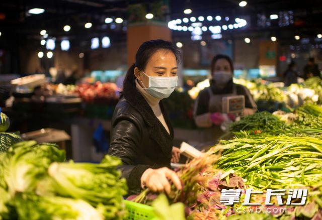 在社區(qū)內(nèi)的農(nóng)貿(mào)市場,，王曼在詢問店主銷售和消毒情況。 