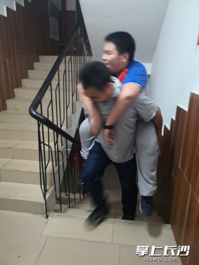 湖南師大附屬思沁中學老師聶玲芝在查寢時巧遇了俞軼背受傷學生回寢的暖心一幕。照片在學校教師群轉發(fā)后,，引發(fā)熱議,。學校供圖