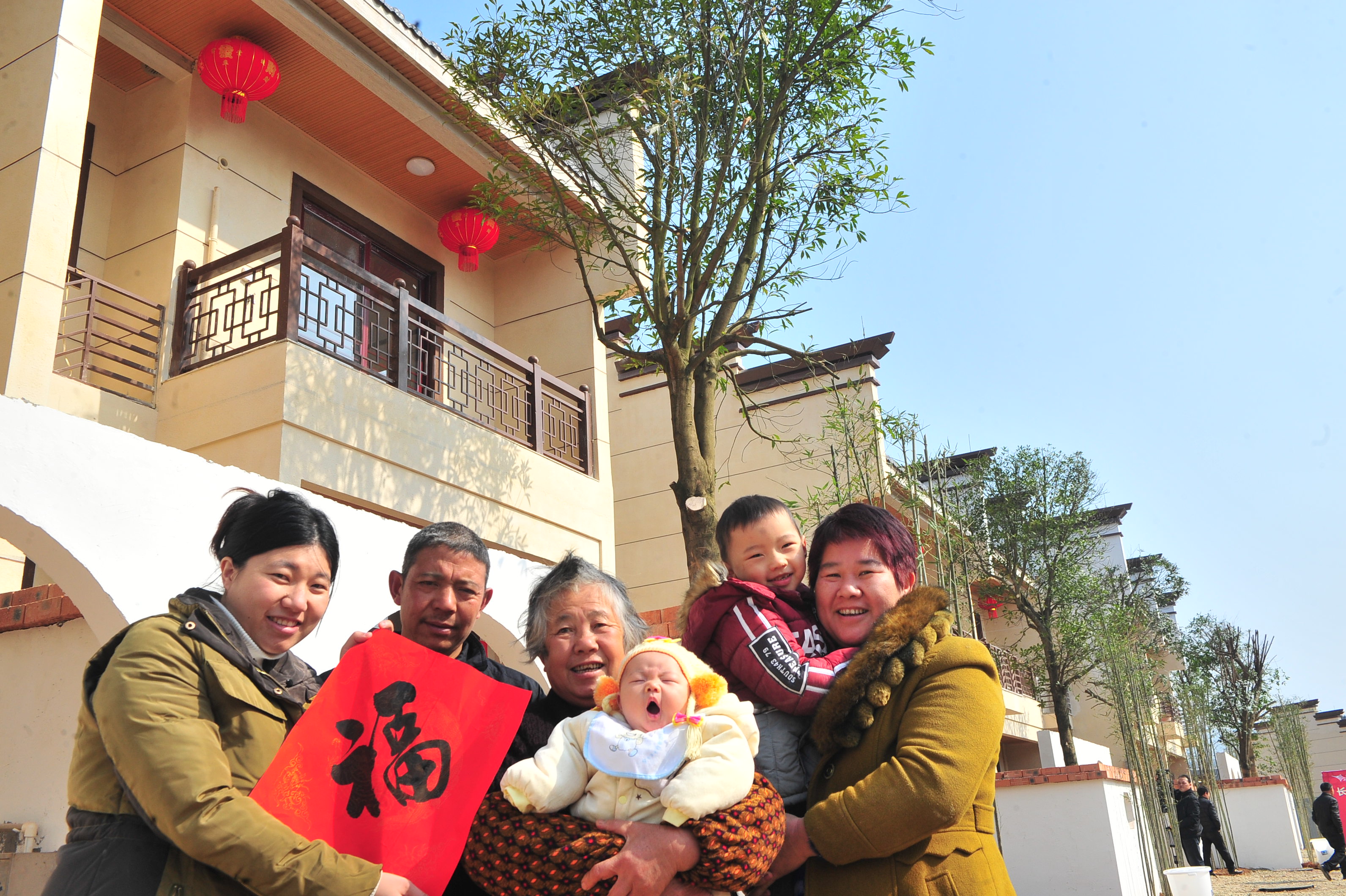 長沙縣高橋鎮(zhèn)易地扶貧搬遷項(xiàng)目白鷺湖生態(tài)小鎮(zhèn),，羅忠海（左二）一家“拎包入住”溫暖的新家，其樂融融拍攝全家福,。長沙晚報全媒體記者 賀文兵 攝