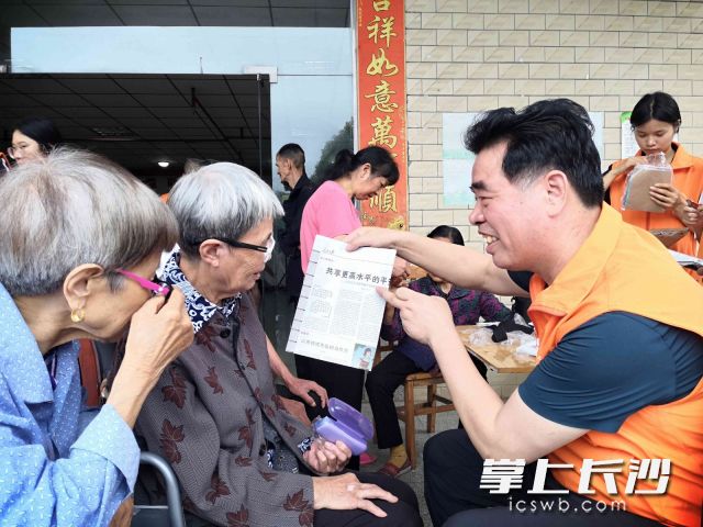 互助會(huì)會(huì)長鄧建明（右一）在為老人免費(fèi)配置老花鏡,。長沙晚報(bào)全媒體記者 賀文兵 攝