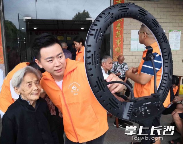 今年99歲,、眼不花耳不聾的李愛蓮?qiáng)謿玻ㄗ笠唬┍粴W堯順（左二）扶著走到正在直播的手機(jī)前,，與網(wǎng)友打著招呼一起互動(dòng)，引來一眾粉絲彈幕點(diǎn)贊,。長沙晚報(bào)全媒體記者 賀文兵 攝