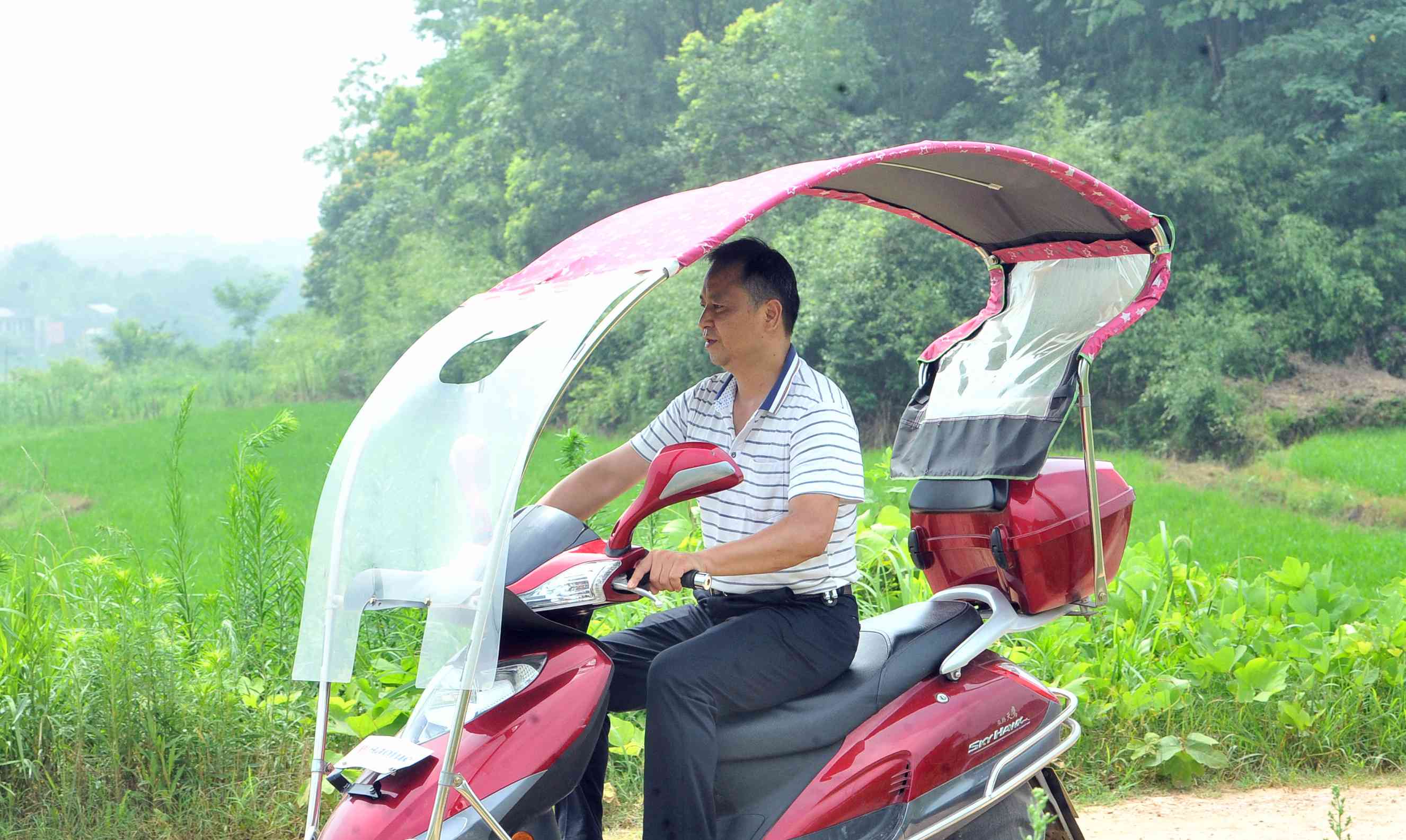 龔宇兵騎著摩托車(chē)走村串戶(hù)。