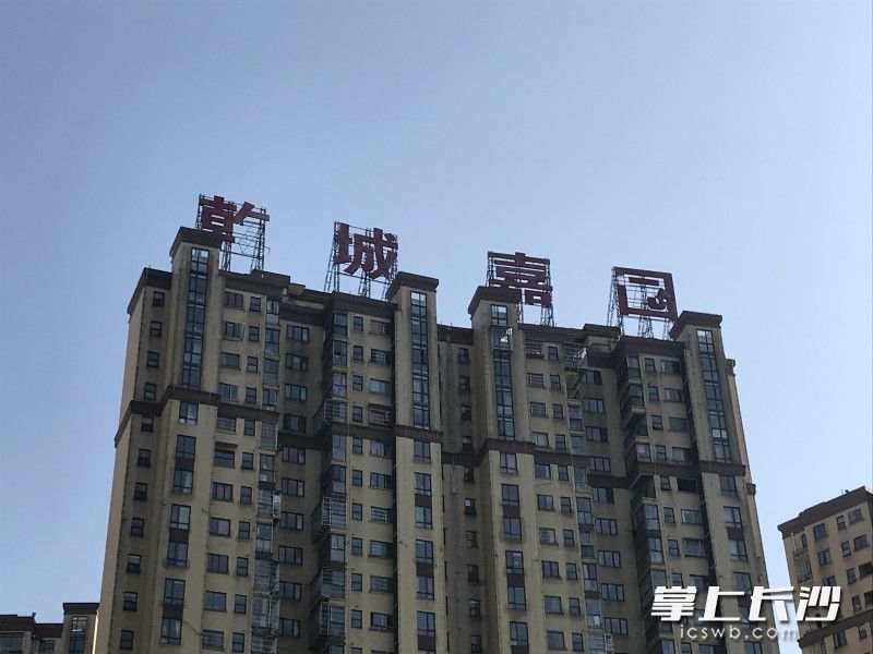 廣告牌上的“乾”和“園”字已經(jīng)掉落了部分筆畫,。