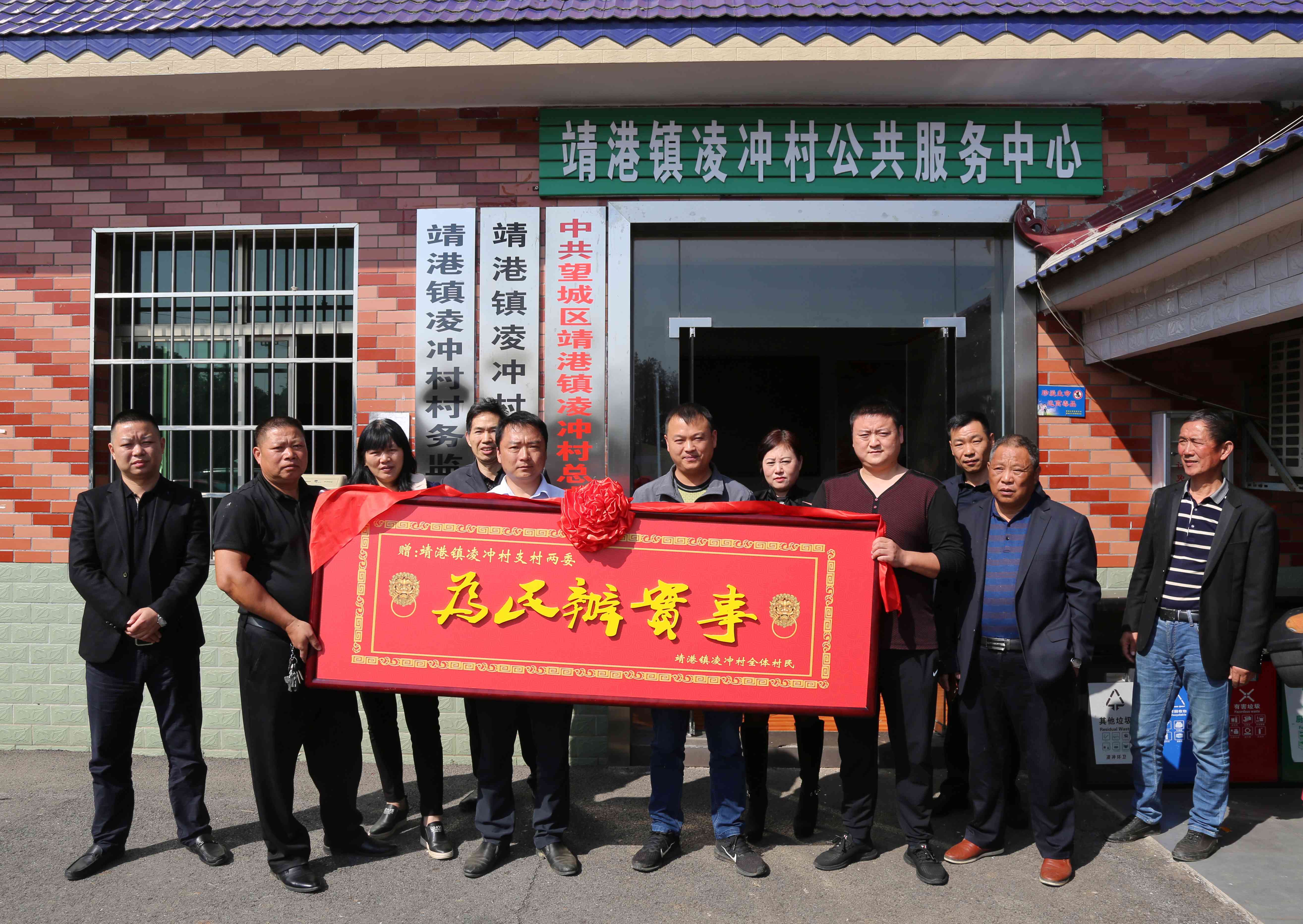 村民將一塊寫著"為民辦實事"的大牌匾抬進村部，感謝村支兩委為老百姓辦好事,。