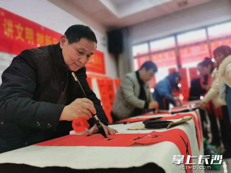 金桂書法隊在活動現(xiàn)場為居民群眾寫春聯(lián),、送福字。