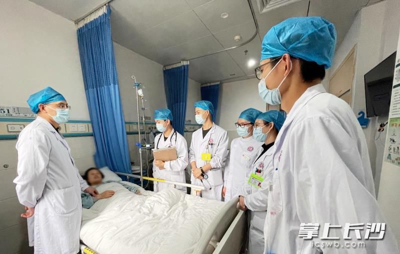 鐘常青副主任醫(yī)師等查看韓女士的恢復(fù)情況。