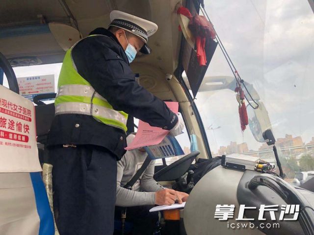 天心交警在“服務站”檢查春運車輛并向駕駛人發(fā)放宣傳資料,。