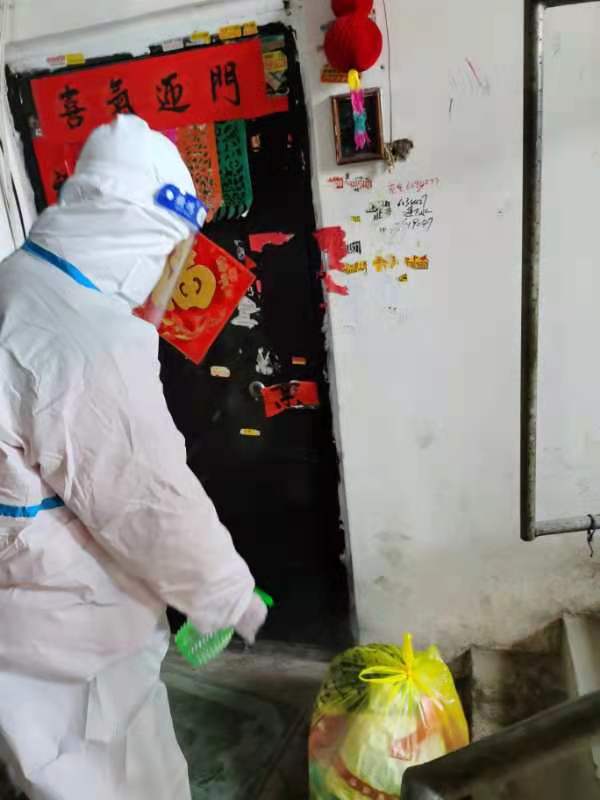李明澤正對居民樓棟的生活物資進行消毒,。