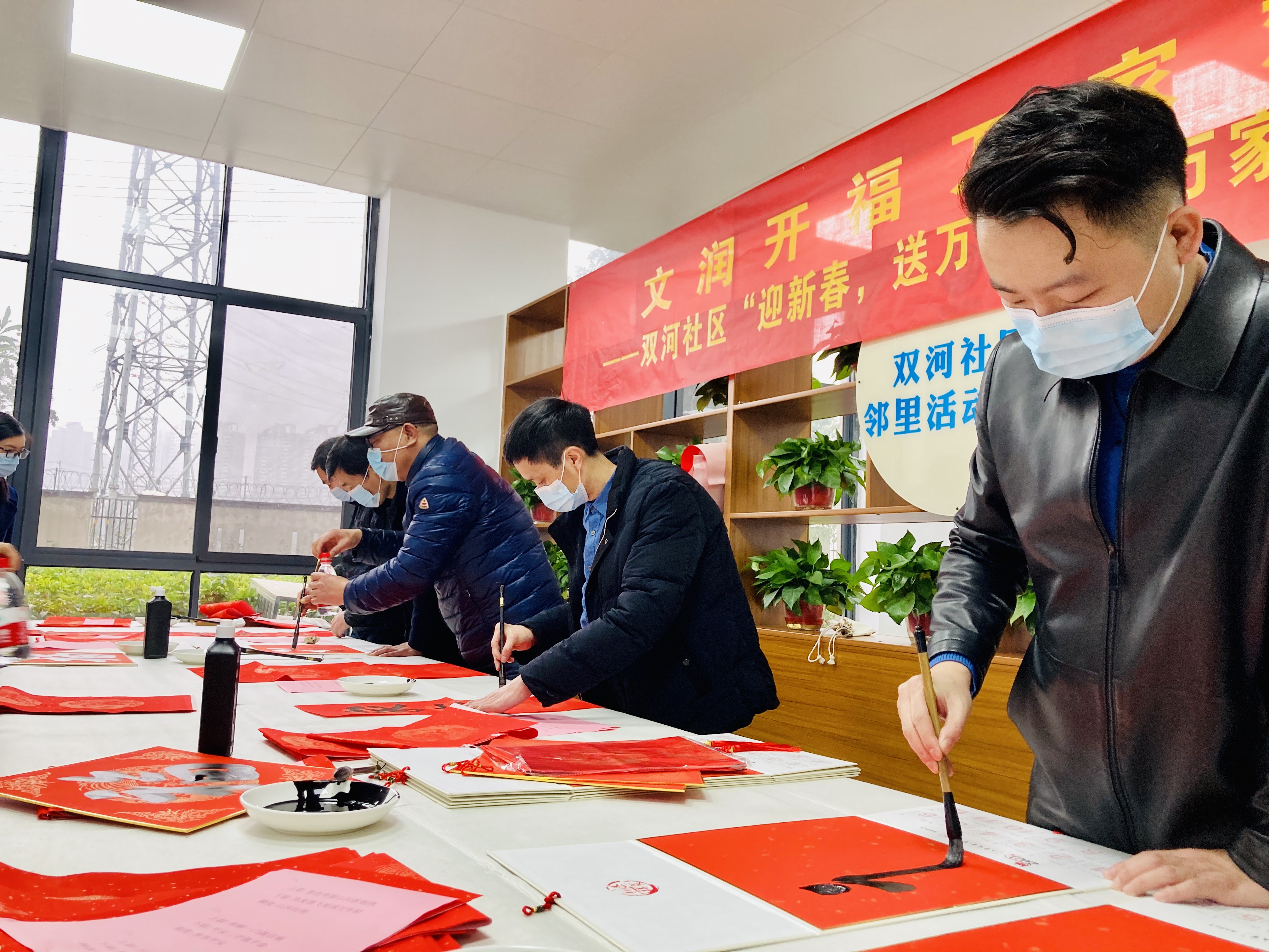 書畫名家走進(jìn)“留守幸福家”，為就地過(guò)年人士和居民寫春聯(lián)送福,。 