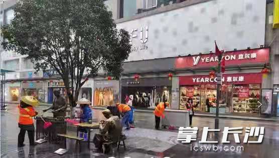 環(huán)衛(wèi)工人正在黃興南路步行街進(jìn)行清掃。