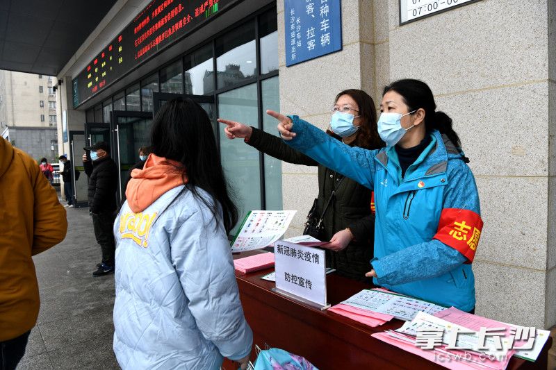 火車站出口志愿者為乘客引路,。