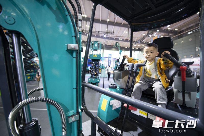 在山河智能展臺，一位小朋友在靜態(tài)體驗挖機的快樂,。
