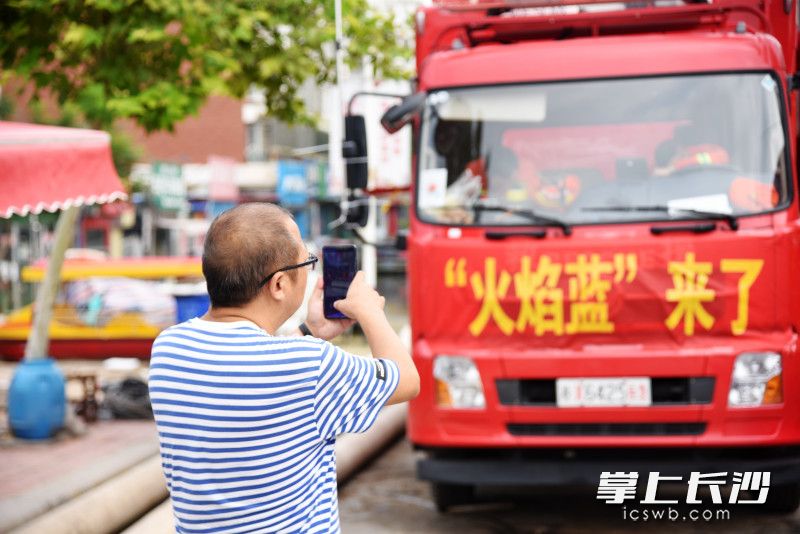衛(wèi)輝市民來到消防車前,，拍照記錄下長沙消防排澇瞬間,。長沙晚報全媒體記者 劉琦 攝