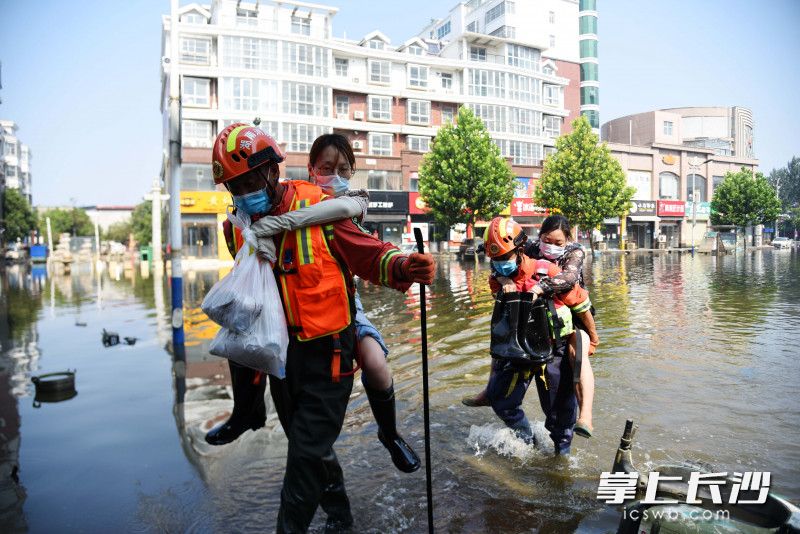 7月31日，在衛(wèi)輝市人民路上,，長沙消防員將兩名女子從積水中背出,。均為長沙晚報(bào)全媒體記者 劉琦 攝