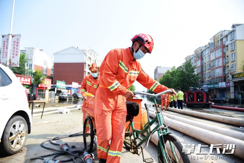 書堂山消防救援站副站長聶嘉利在排澇一線清理積水中的垃圾,。長沙晚報全媒體記者 劉琦 攝