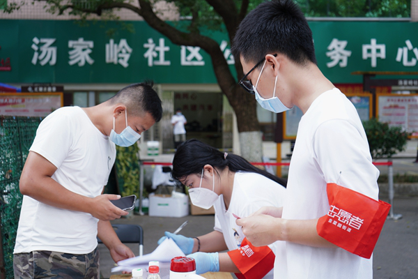 志愿者曾胤哲為居民測量體溫。