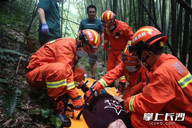 成功下山后,，消防指戰(zhàn)員將被困女子移交給醫(yī)務(wù)人員救治。
