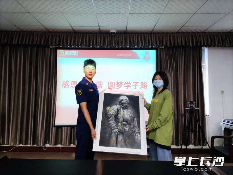 學(xué)生小趙將自己親手繪制的素描《消防員》送給望城消防救援站全體消防指戰(zhàn)員,。長沙晚報(bào)通訊員 楊來富 供圖