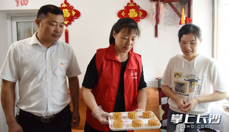 孫家闖（左）與志愿者一同將做好的月餅送到社區(qū)困難群眾家中,。