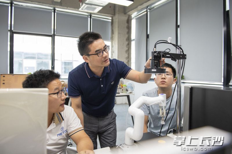 周博文（中）與同事在工作中,。長沙晚報全媒體記者 郭雨滴 攝