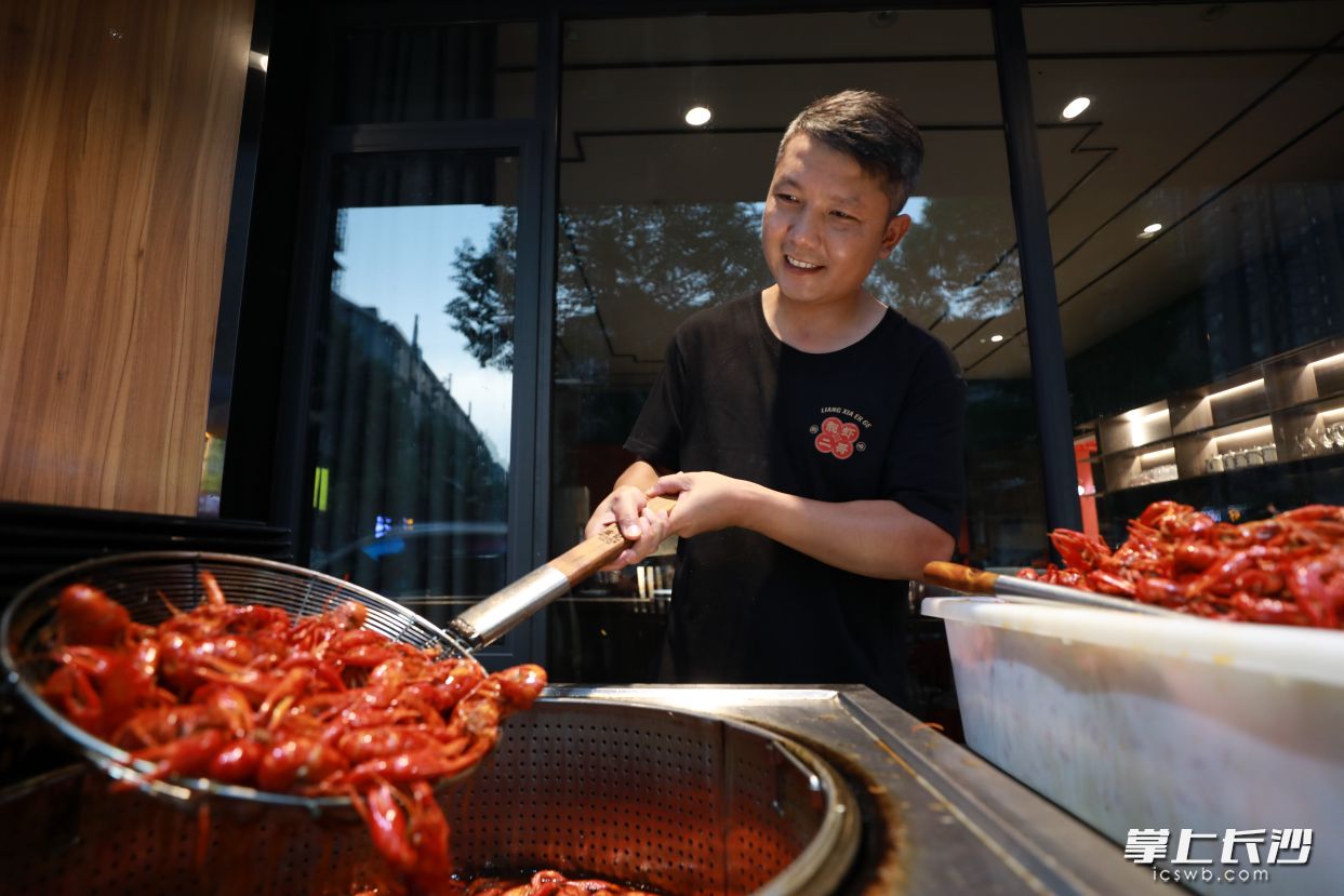 150平方米的老店升級為“靚蝦二哥”,，劉權(quán)撈起剛出鍋的大蝦,，心里美滋滋的。   均為受訪者供圖