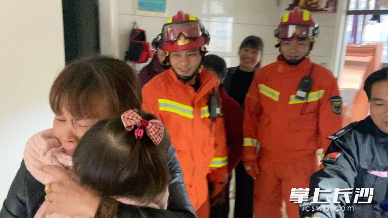 消防員將門打開后,，奶奶一把抱起孫女,。均為視頻截圖