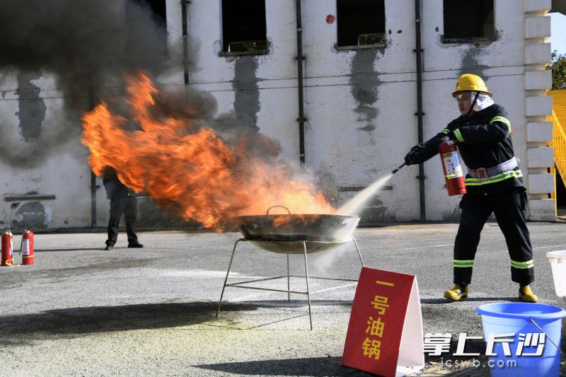 參賽隊(duì)員使用滅火器撲滅油鍋大火。長沙晚報(bào)通訊員 唐雄杰 全媒體記者 劉琦 攝