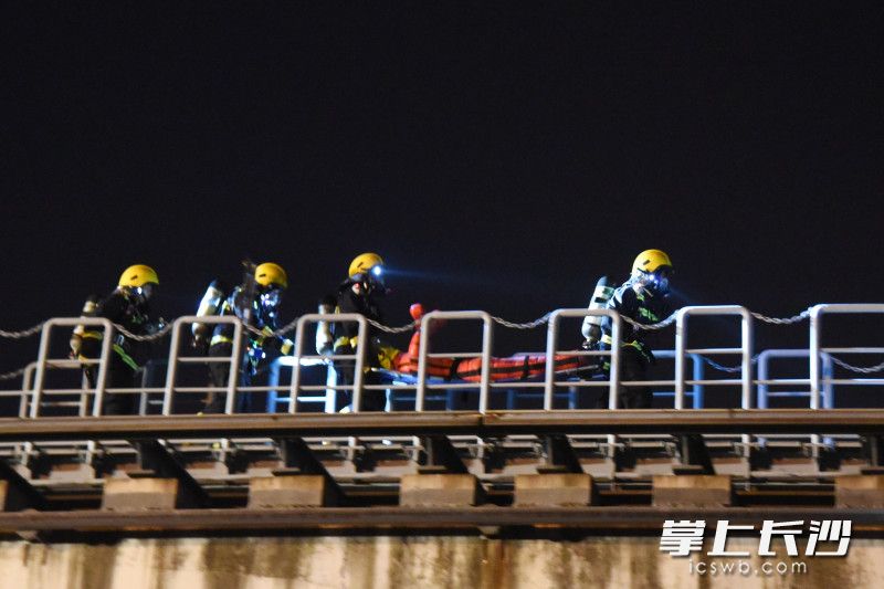 磁浮軌道上,，消防員將“被困人員”救出,，向安全地帶轉(zhuǎn)移。
