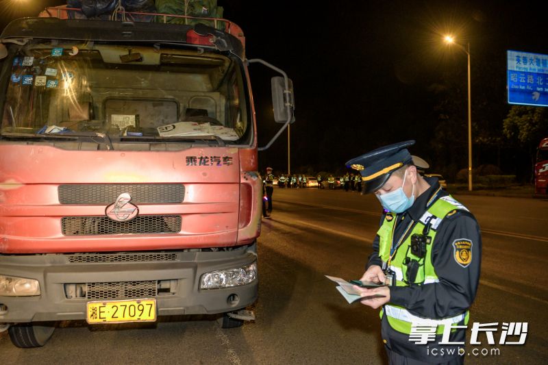執(zhí)法人員仔細核對車輛信息。均長沙晚報全媒體記者 陳飛 攝