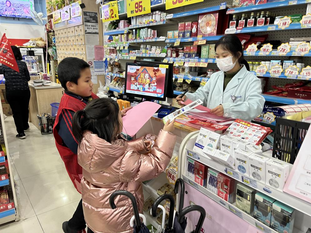 小志愿者將宣傳頁送到門店經(jīng)營者手中。長沙晚報(bào)通訊員 呂巧莉 供圖