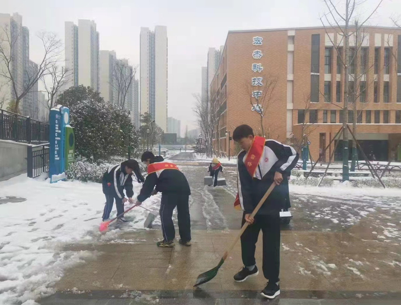 長沙市一中金山橋?qū)W校內(nèi)，幾名學(xué)雷鋒志愿者們正在掃雪,。均為長沙晚報通訊員 彭園琛 供圖