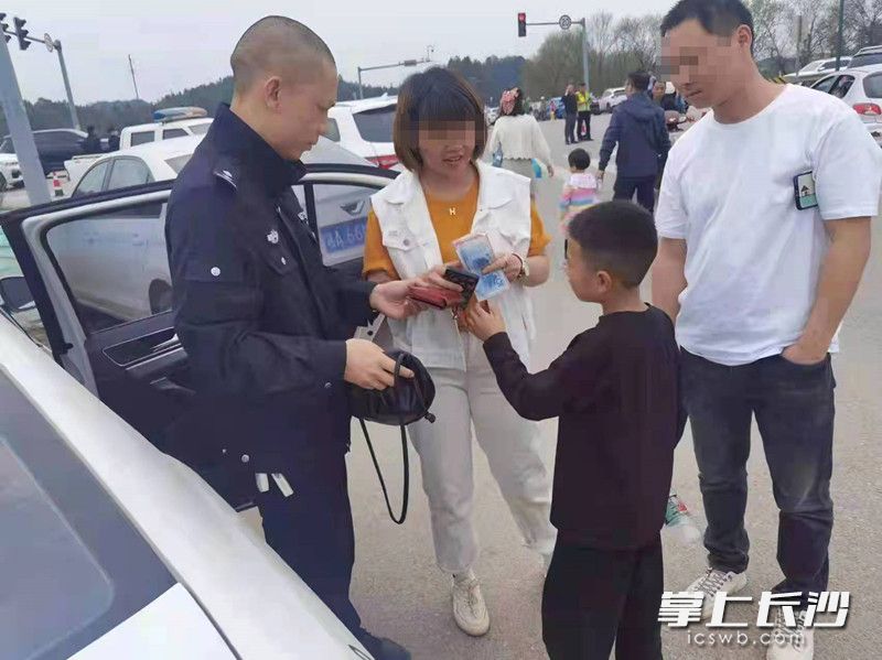 警務(wù)人員羅湖洲（左一）將錢包歸還給失主劉女士,。江背派出所供圖