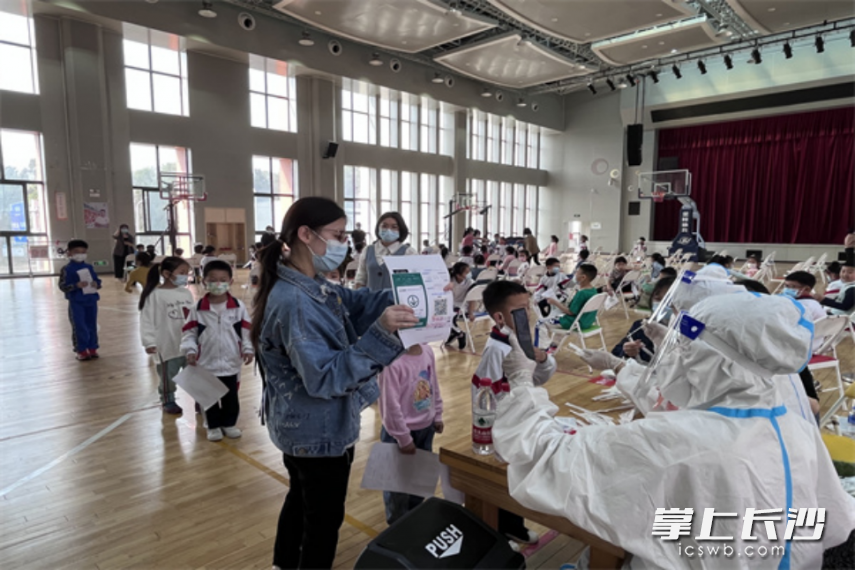 醫(yī)護(hù)人員和志愿者為小朋友做核酸檢測(cè),。長(zhǎng)沙晚報(bào)全媒體記者 王斌 攝