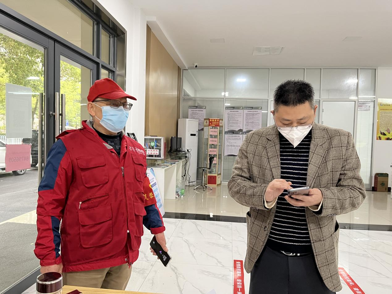 黃能明（左）正在防疫一線忙碌。長(zhǎng)沙晚報(bào)通訊員 朱映鍇攝