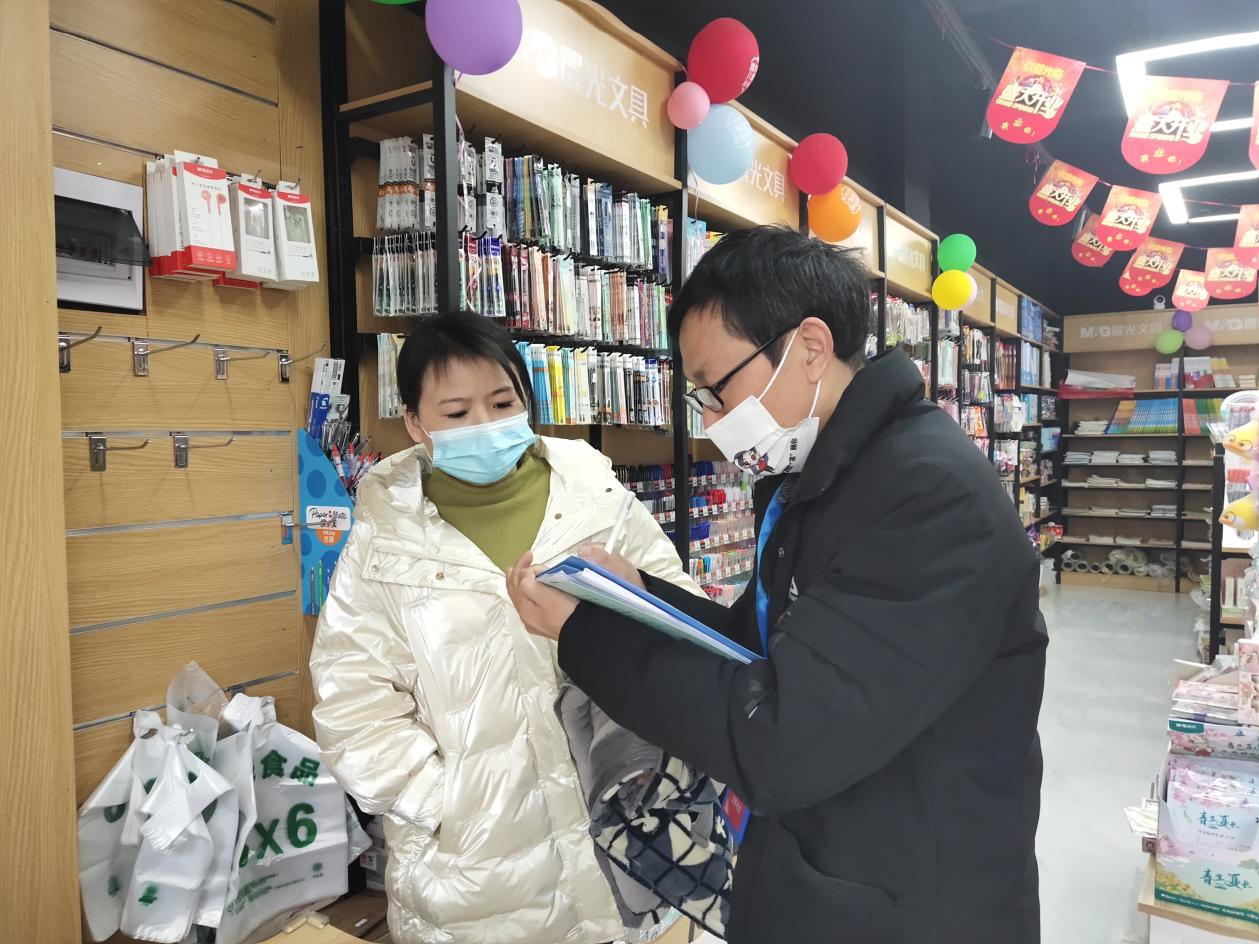 夏四美（右一）在社區(qū)走訪門店,，開展疫情防控工作。供圖