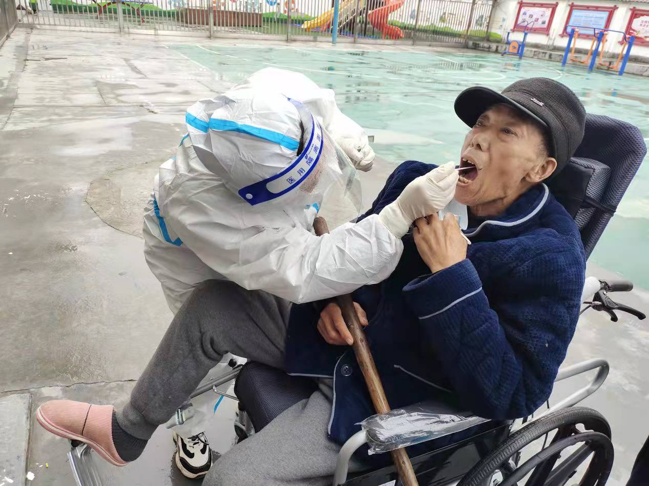 興馬洲村醫(yī)顏新艷為坐在輪椅上的老人進(jìn)行核酸檢測(cè)采樣,。長(zhǎng)沙晚報(bào)通訊員 閆林 供圖