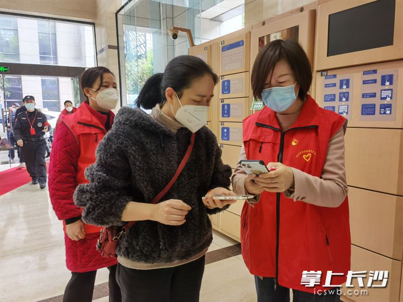 五十七度湘黨員志愿者引導(dǎo)樓宇企業(yè)員工掃場所碼,。長沙晚報(bào)通訊員 石琛 供圖