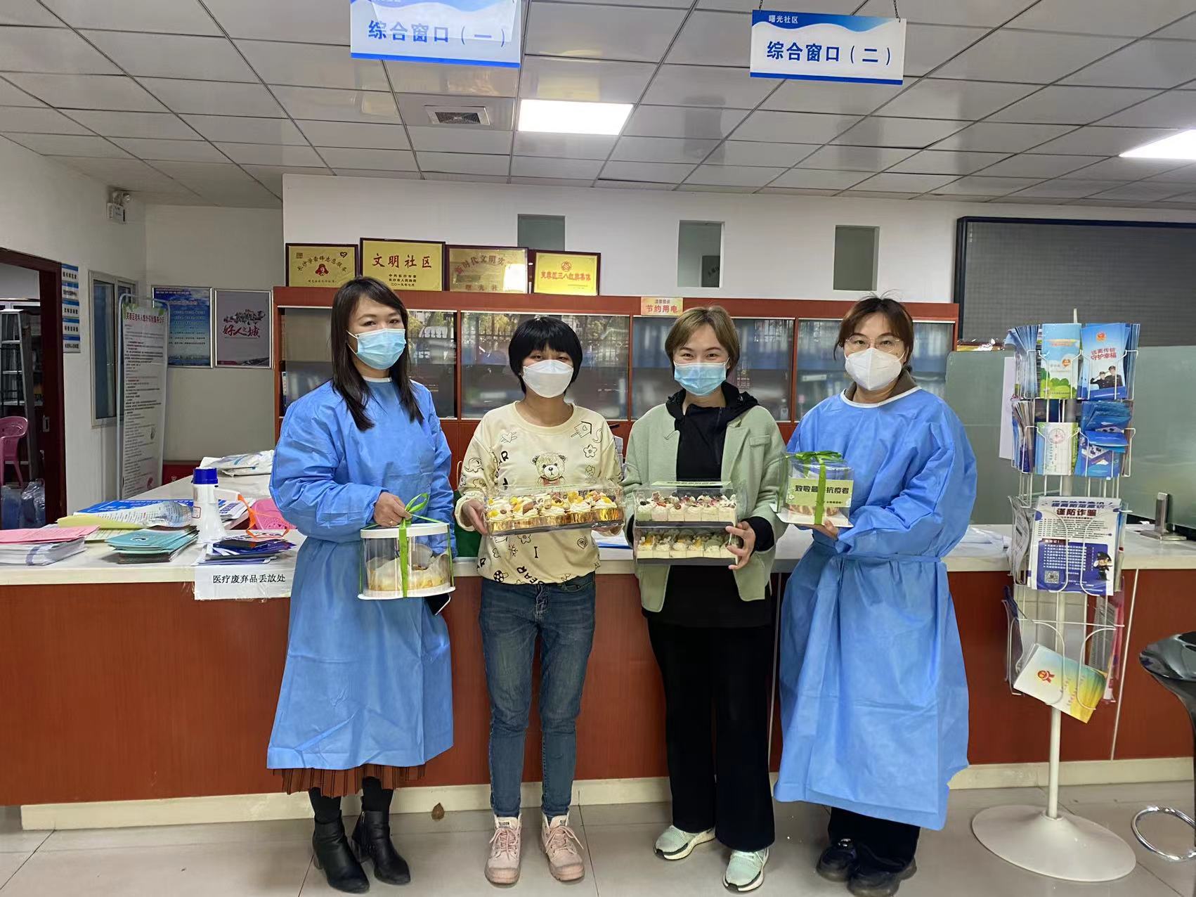 王莉丹（左二）將連夜趕制的1000份愛心小蛋糕,，送到朝陽街道一線戰(zhàn)“疫”者手中,。