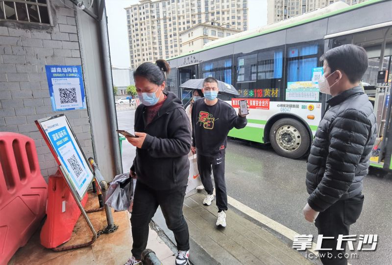 在寧鄉(xiāng)客運(yùn)汽車南站出口設(shè)置的疫情防控檢測(cè)點(diǎn),，乘客在工作人員的引導(dǎo)下掃碼出站,。長(zhǎng)沙晚報(bào)全媒體記者 張禹 攝