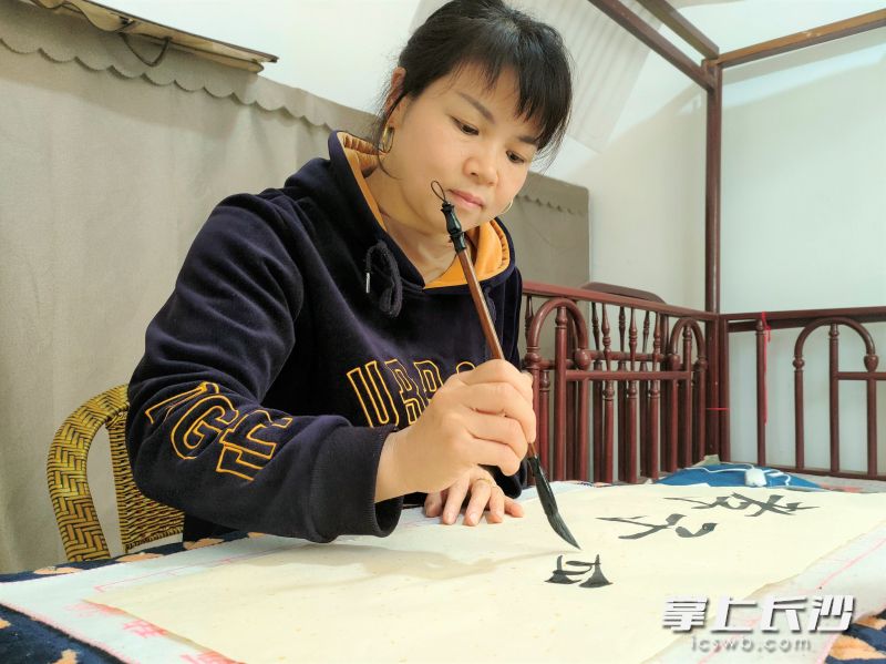 把家人們安頓妥帖之后，李寧波喜歡練字陶冶情操,。長沙晚報全媒體記者 張禹 通訊員 李向 周杰 攝影報道