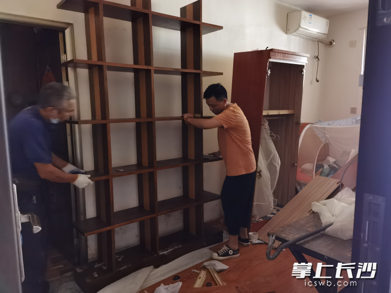 工人正在拆除其中一面隔離墻,。