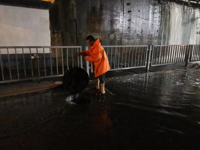 雨花市政工作人員打開下水井蓋排水,。