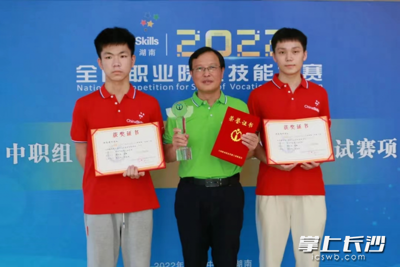 譚文彪（右）,、周鋒（左）賽后和指導(dǎo)老師合影。  均為市教育局供圖