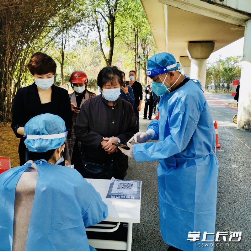 “支部在線”志愿者為核酸采集點(diǎn)老年人提供貼心的智能手機(jī)輔助服務(wù)。