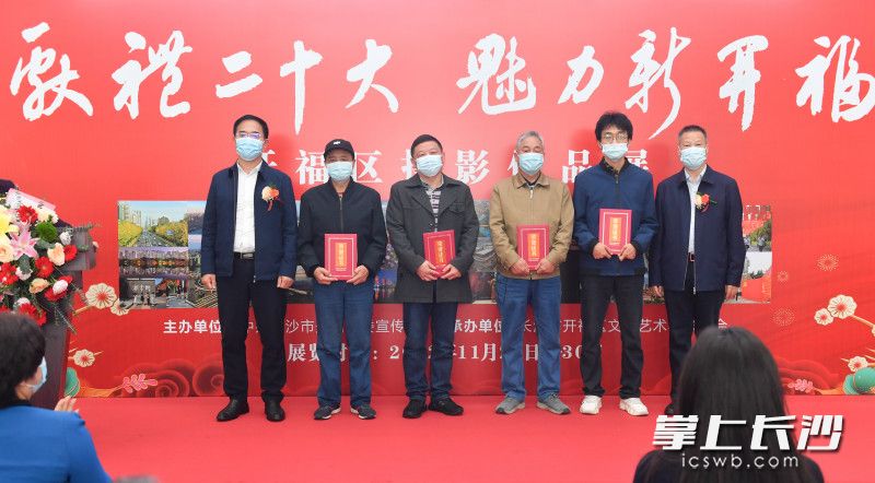 11月27日,，“獻(xiàn)禮二十大 魅力新開?！睌z影作品展在開福區(qū)政府一樓大廳展出。圖為與會(huì)領(lǐng)導(dǎo)給獲獎(jiǎng)攝影師頒獎(jiǎng),。長(zhǎng)沙晚報(bào)全媒體記者 鄒麟 攝