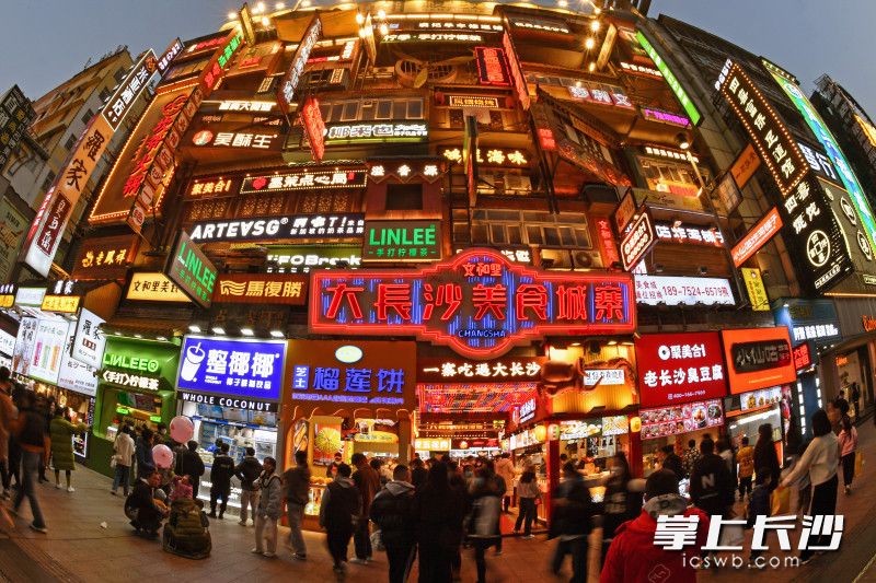 今晚6時許，黃興南路步行商業(yè)街，大長沙美食城寨各種招牌在夜幕下熠熠生輝,，游客在此流連忘返,。 均為長沙晚報全媒體記者 王志偉 攝