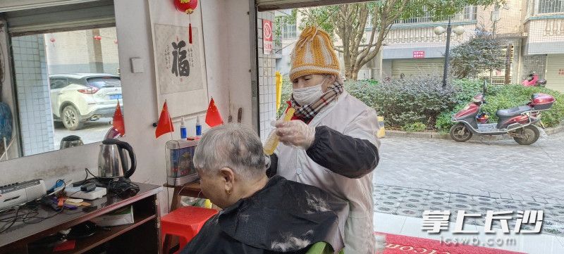 唐金連在給居民理發(fā)。  均為長沙晚報全媒體記者鄧艷紅攝