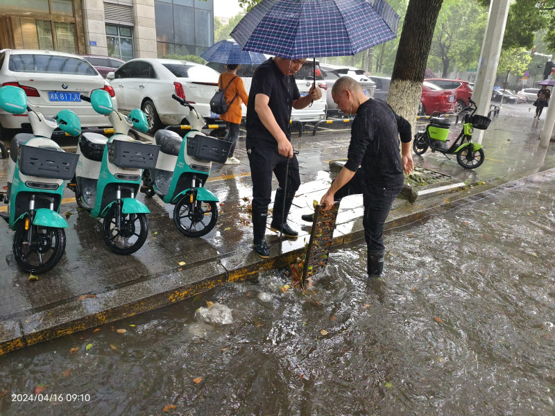 網(wǎng)格員方建興擼起衣袖,，冒雨徒手將堵塞在下水道的樹枝雜物都清理出來,。